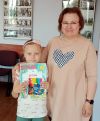 Dziecko pozuje do zdjęcia z instruktorką i dyplomem